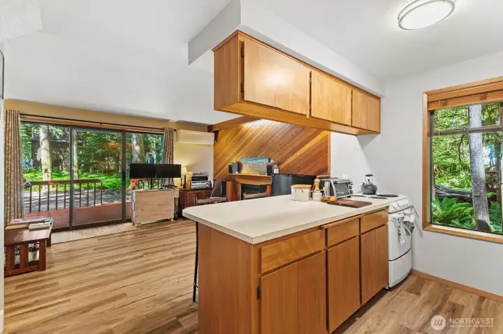 Functional kitchen featuring ample counter space, wood cabinetry, and open sightlines to the living area.