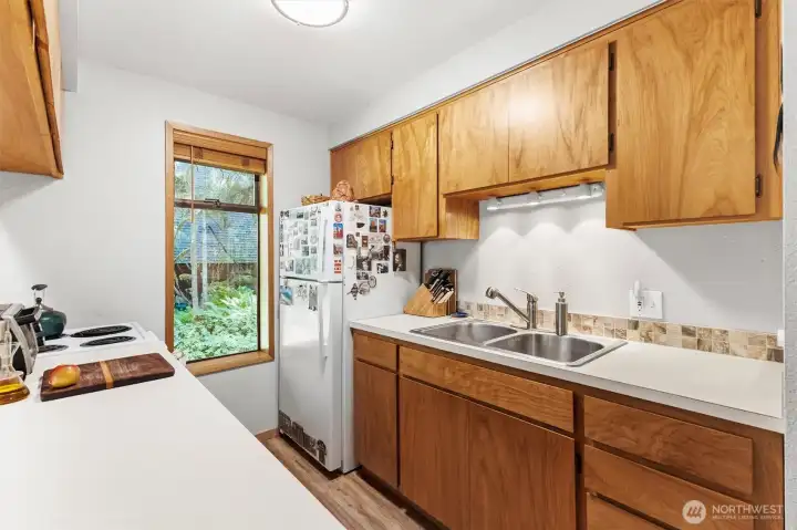 Kitchen offers generous storage, custom wood cabinetry, and easy access to the dining space.