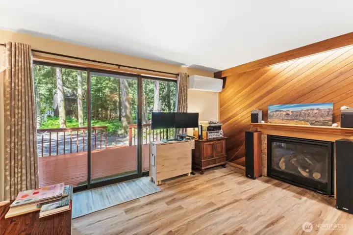 Cozy living area highlighted by a propane fireplace and access to the outdoor deck.