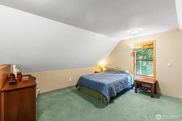 Upper-level sleeping area with vaulted ceilings and flexible layout options.