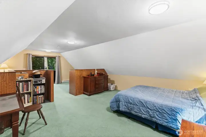 loft bedroom offers a peaceful retreat overlooking the wooded surroundings.