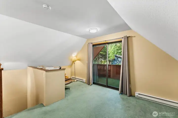 Loft area with access to the upper deck and views of the surrounding forest.