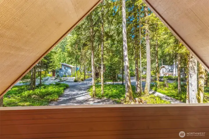 Elevated deck overlooks the peaceful wooded setting.
