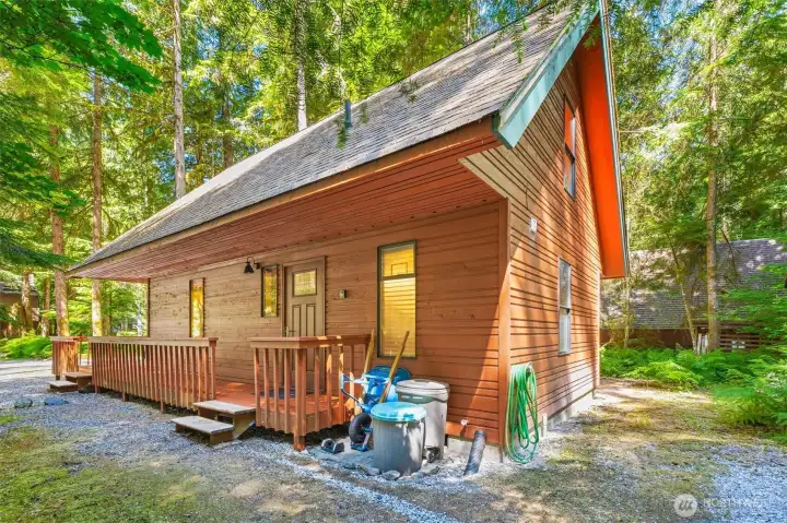 Side exterior view highlighting the cabin's natural wood siding and forested surroundings.
