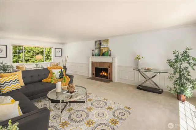 Large living with room with wood burning fireplace and large windows.