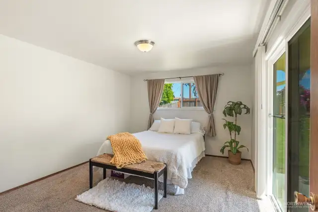 Primary bedroom steps out to back patio through sliding door