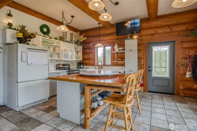 Country living Kitchen space - custom built wood table as an island that extends with spare legs to host a large group of people