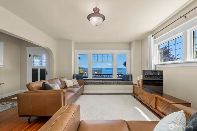 Expansive windows flood the living room with natural light and frame breathtaking water views.