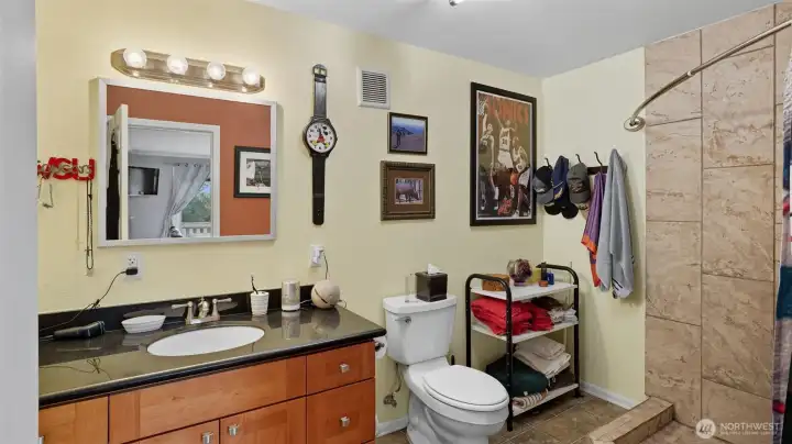 Functional 3/4 bath featuring tile shower surround and ample storage.