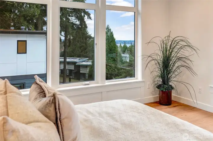 Primary suite offers peaceful treetop outlook with a filtered Lake Washington + Olympic Mountain view.