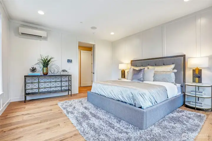 Generously sized primary bedroom, French door entry into a vestibule, elegant painted millwork paneling, and a serene retreat atmosphere. Views to the west of the Olympic Mountains and filtered lake views.