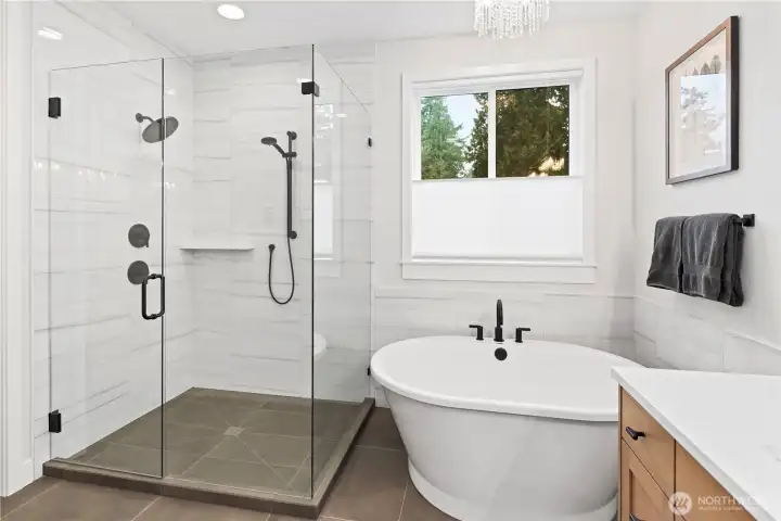 A spa-caliber retreat featuring a freestanding soaking tub, an expansive frameless glass shower, and heated large format porcelain tile floors.