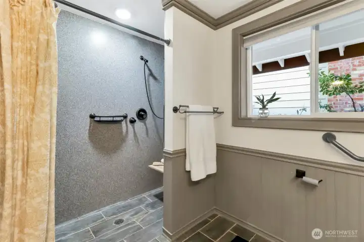 Accessible shower with double heads and fold down shower seat.