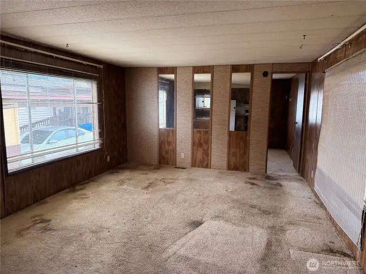 Large family room off kitchen with 2 large windows and second primary bedroom at front of home with bathroom