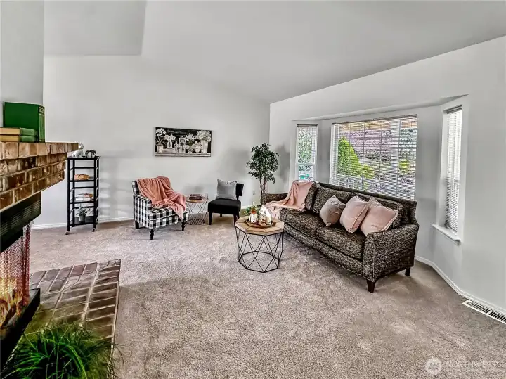 Living room view from the front door...vaulted living room with corner fireplace, bay style front window,fresh paint and brand new carpets.