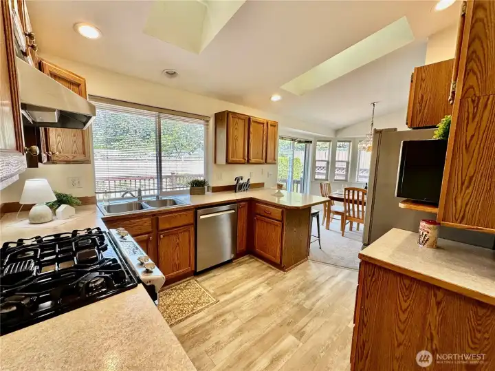 You will love the kitchen conveniently located between the dining and livinr room with skylight above the eating bar, newer stainless appliances and laminate flooring.