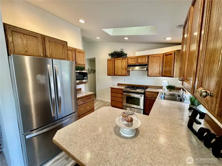 The kitchen offers lots of natural light with skylight and window above the sink, ample counter space and cabinets plus pantry.