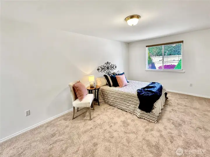 Primary bedroom with picture window offering natural light and view of the rear yard.