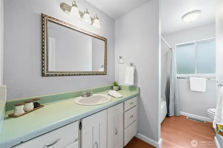 Bright, clean, and well-appointed — the main hall bath serves the two secondary bedrooms without skipping a beat. A wide vanity gives everyone their own space at the counter, and the tub-shower combo means it works just as well for bath time as it does for busy mornings.