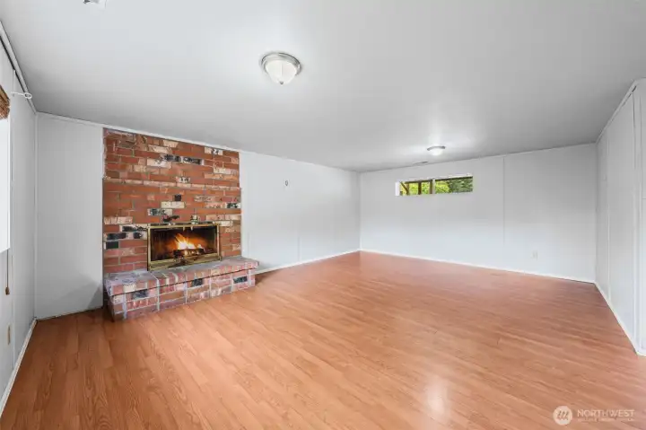 The lower-level family room features its own wood-burning fireplace and enough space to finally have a room for everything — movie nights, game days, a playroom, or the man cave that keeps the upstairs peaceful.