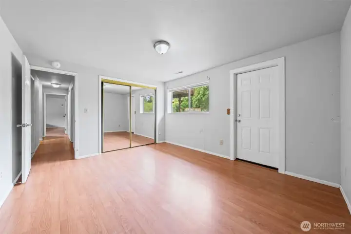 Bedroom Four features a mirrored closet, warm laminate flooring, and something most first-time buyers never expect to find — its own private exterior door. With a ¾ bath and laundry already on the lower level, this space has real potential to generate rental income that helps offset your mortgage every single month. House hacking in Kent, with Amazon and Boeing workers actively looking for housing nearby — this is how smart first-time buyers get ahead.