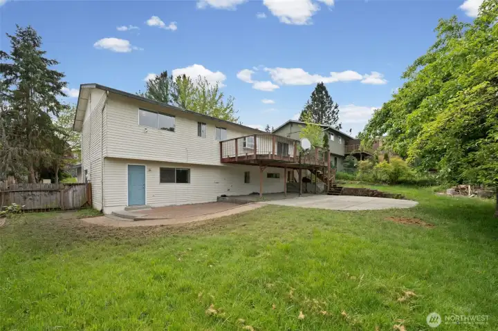 The outdoor infrastructure is already in place — elevated deck, brick paver patio, private lower-level exterior door, and a fully fenced yard with mature trees. Level and big = a major value driver.