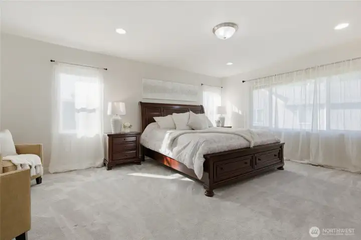 Elegant primary suite has room for a sitting area and is flooded with light!