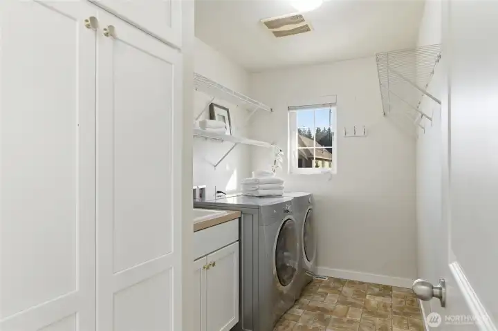 Convenient laundry room with lots of cabinetry and utility sink!