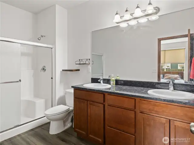 The primary bathroom boasts granite countertops and a spacious layout for comfort and style.