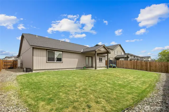 Fully fenced back yard with underground sprinkler system.