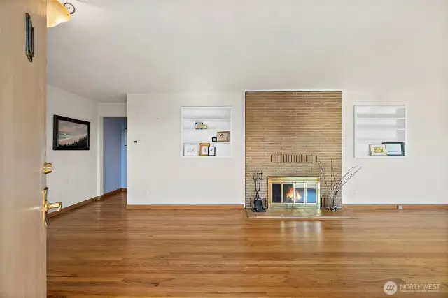 Front entry opens to a welcoming fireplace between the living (to right) and dining space (to left) with built-ins flanking either side to show off your style.