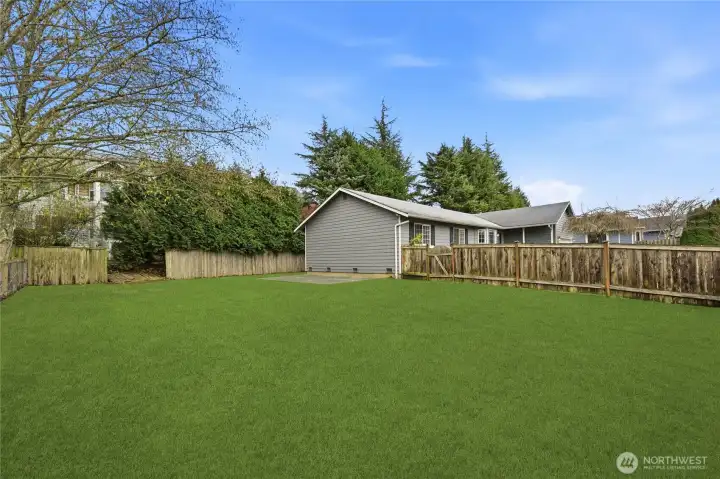 Spacious and fenced backyard offering multiple areas to enjoy the outdoors.