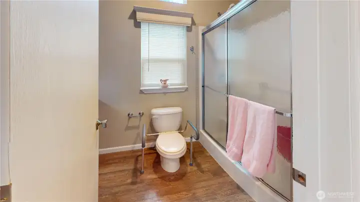 The bathroom features a large walk-in shower with seat and good size vanity with ample storage.