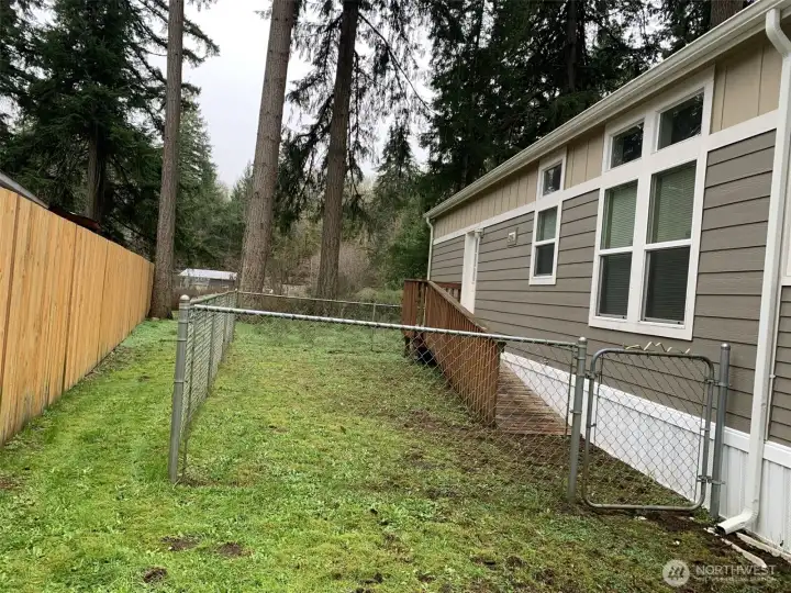 Fenced side yard with ramp leading to side entry.