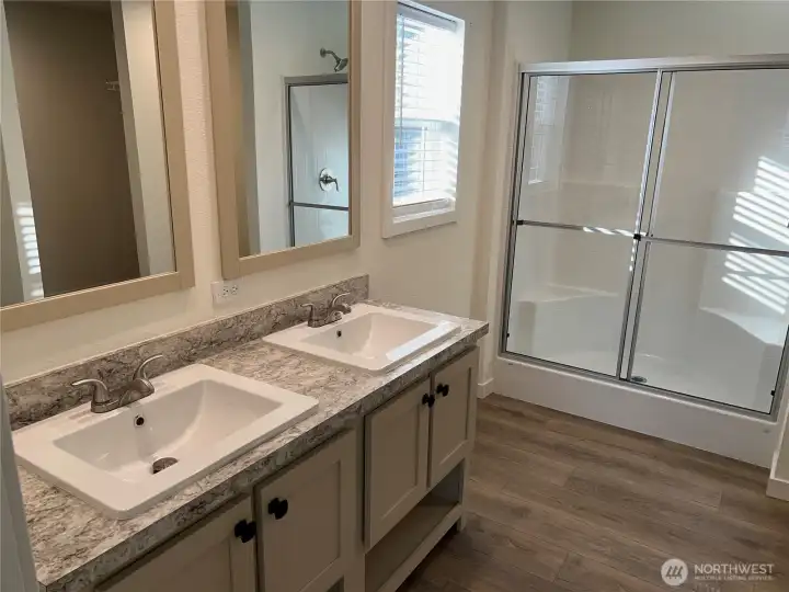 Primary bath with double vanities and walk in shower.
