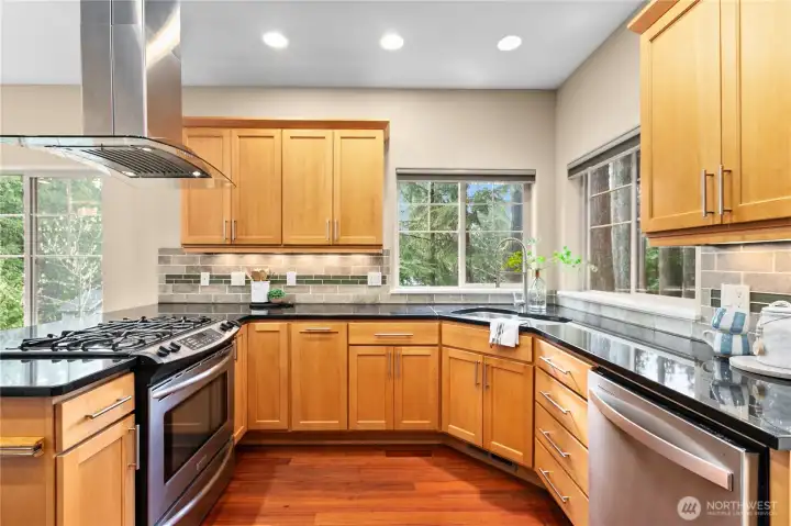 Kitchen with solid surface countertops, tile backsplash, and multiple windows bringing in natural light.