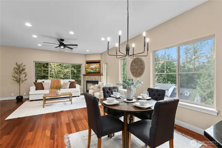 Dining space with large windows and overhead lighting, positioned adjacent to kitchen.