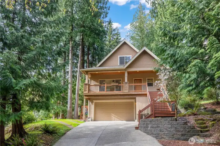 Front exterior with covered entry, elevated deck, and attached garage