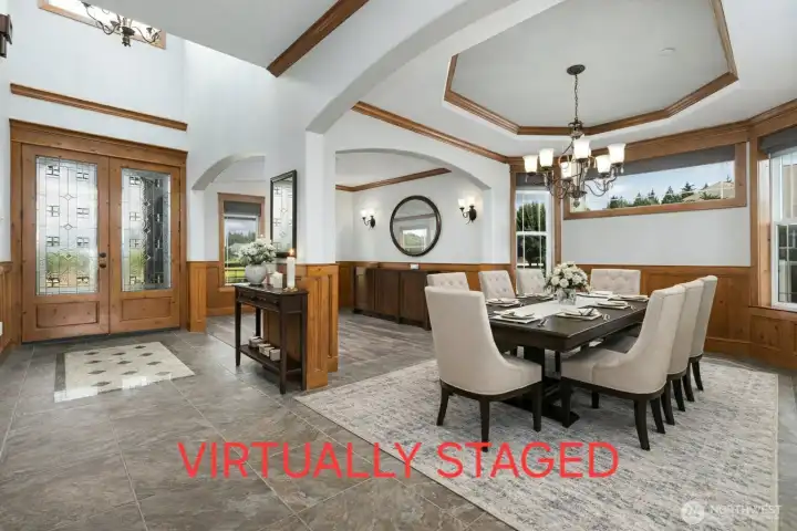 View of Entry, Formal Dining and Living Room in the back.  This is virtually staged, and the back right wall in the living room where the circular mirror is, actually has a window there.