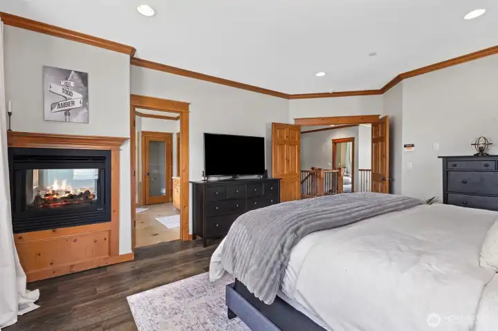 Primary bedroom with two sided fireplace. Other side of the fireplace is in the primary bath at the tub.