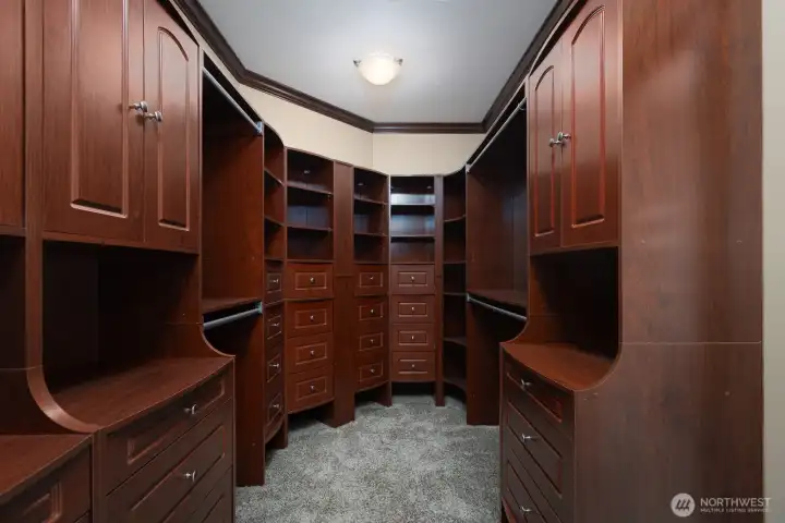 Primary walk in closet with custom built ins