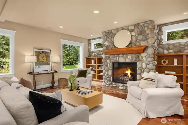 The spacious family room features  river rock clad fireplace, built-in bookshelves.