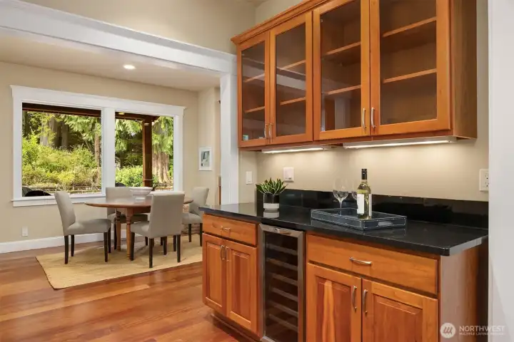 A butler's pantry with dry bar with under-counter wine  refrigerator  connects the kitchen to the dining room.