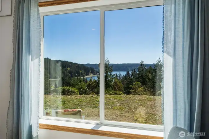 Living room view: a stunning picture-window panorama of Hood Canal and the peninsula—your daily backdrop for sunrise coffee and golden-hour sunsets.