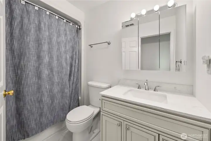 Stylish second bath with quartz counters and matching quartz flooring—fresh, clean finishes with great everyday function.