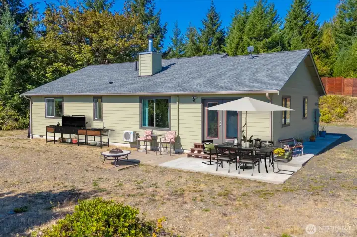Sunny patio off the living area—perfect for morning coffee, fresh air, and easy indoor-outdoor living, surrounded by evergreens and privacy.