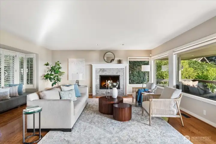 Elegant and light-filled, the formal living room captures natural light from both north and south exposures and features a cozy fireplace insert and hardwood floors.