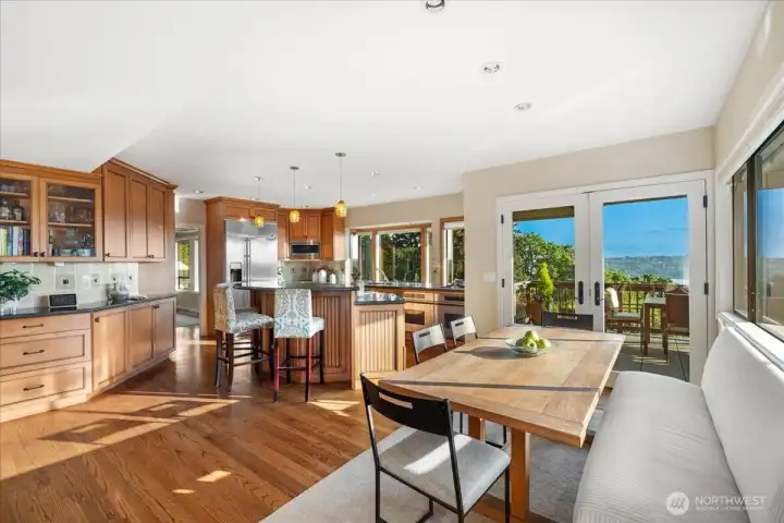 This kitchen features a spacious island with bar seating, a built-in breakfast nook, abundant storage, and chef-quality stainless steel appliances.