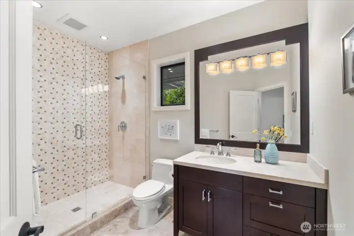 The spacious ensuite bathroom features heated floors, making this bedroom both comfortable and functional.