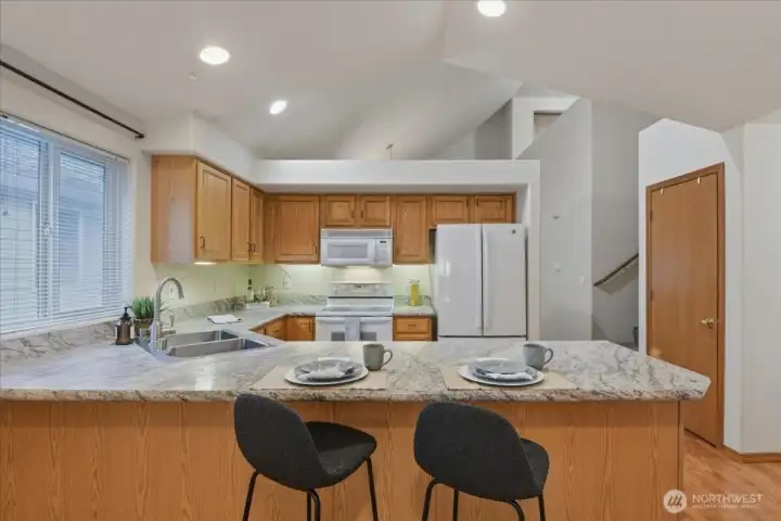 Kitchen with peninsula and eat bar, vaulted ceilings, laminate floor